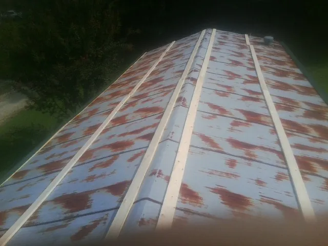 Rusted metal roof panels with new wood purlins before replacement — Storm Damage Roof Repair in Powers Lake by Roofing Brothers