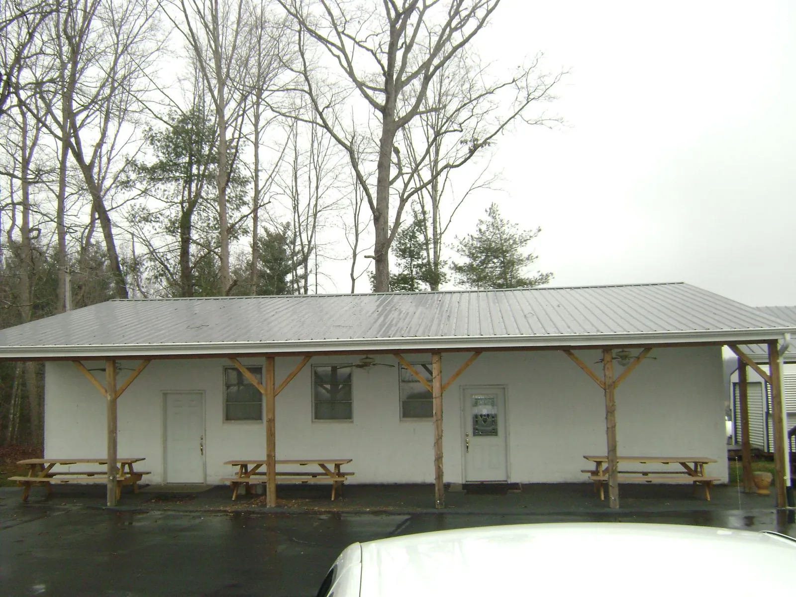Gray metal roof over a block building with a timber post porch in Powers Lake